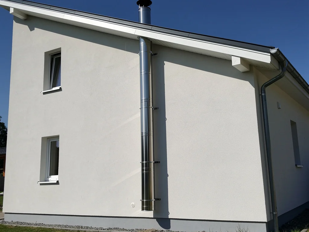 Tubage inox d'un conduit de fumée le long d'un mur extérieur crépi